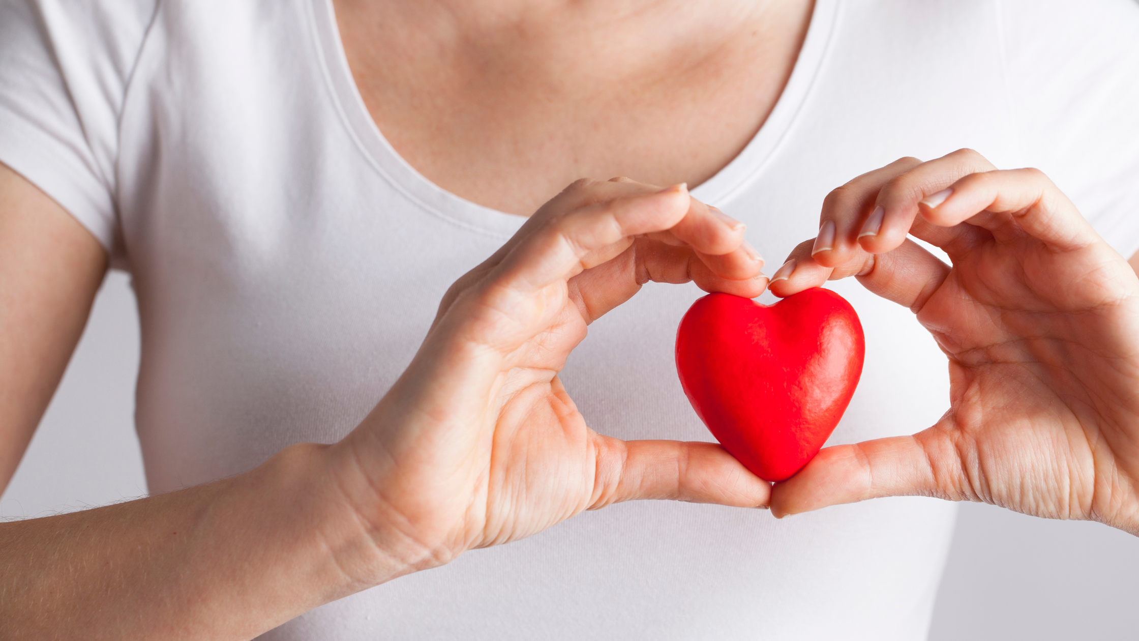 woman holding a small cartoon heart over her chest