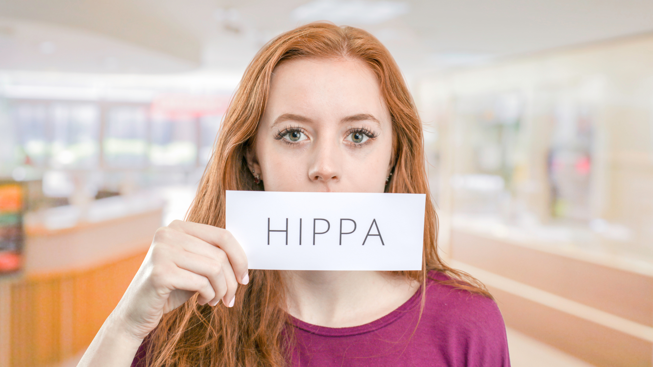woman holding a piece of paper with "HIPPA" on it